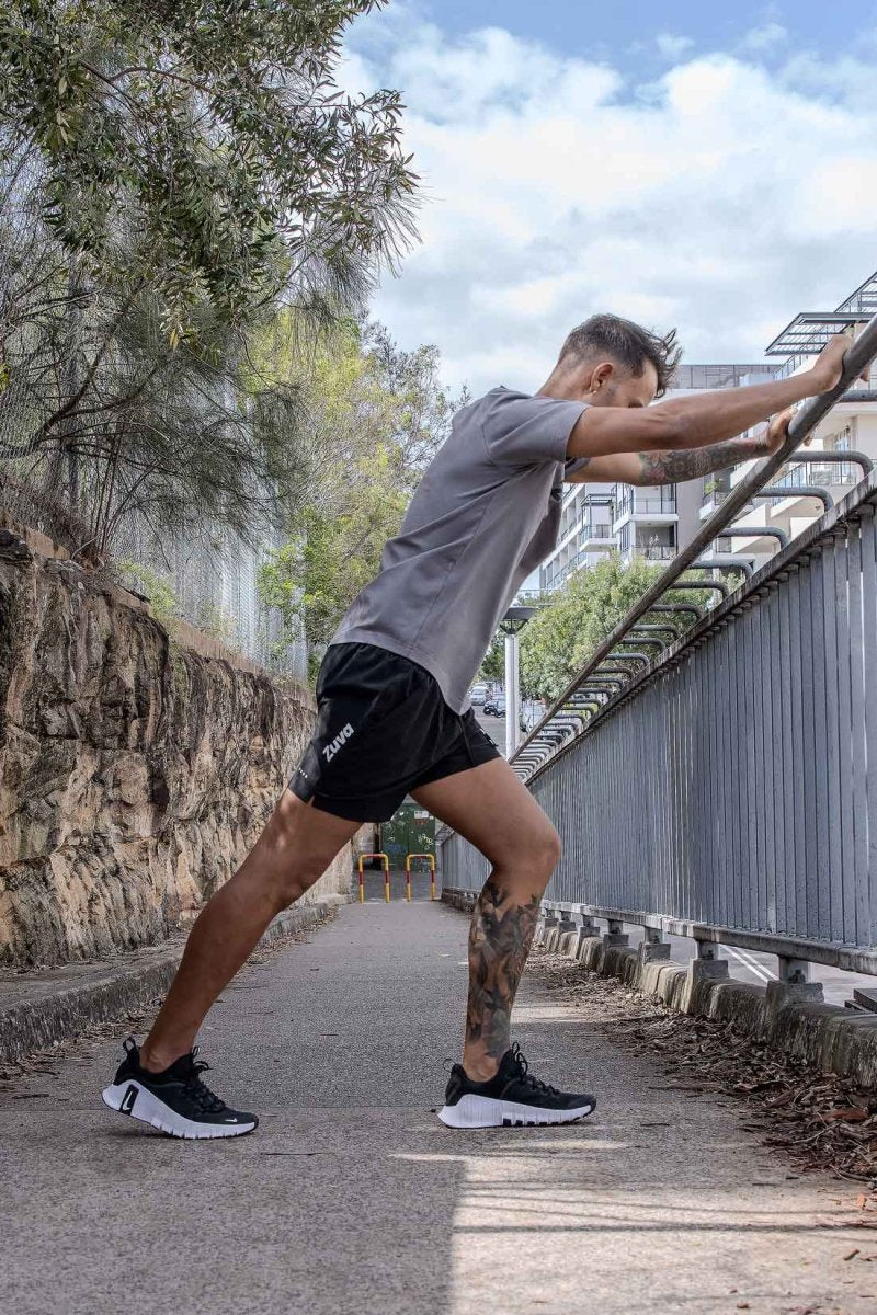Aussie male wearing Australian brand Zuva stretching in street