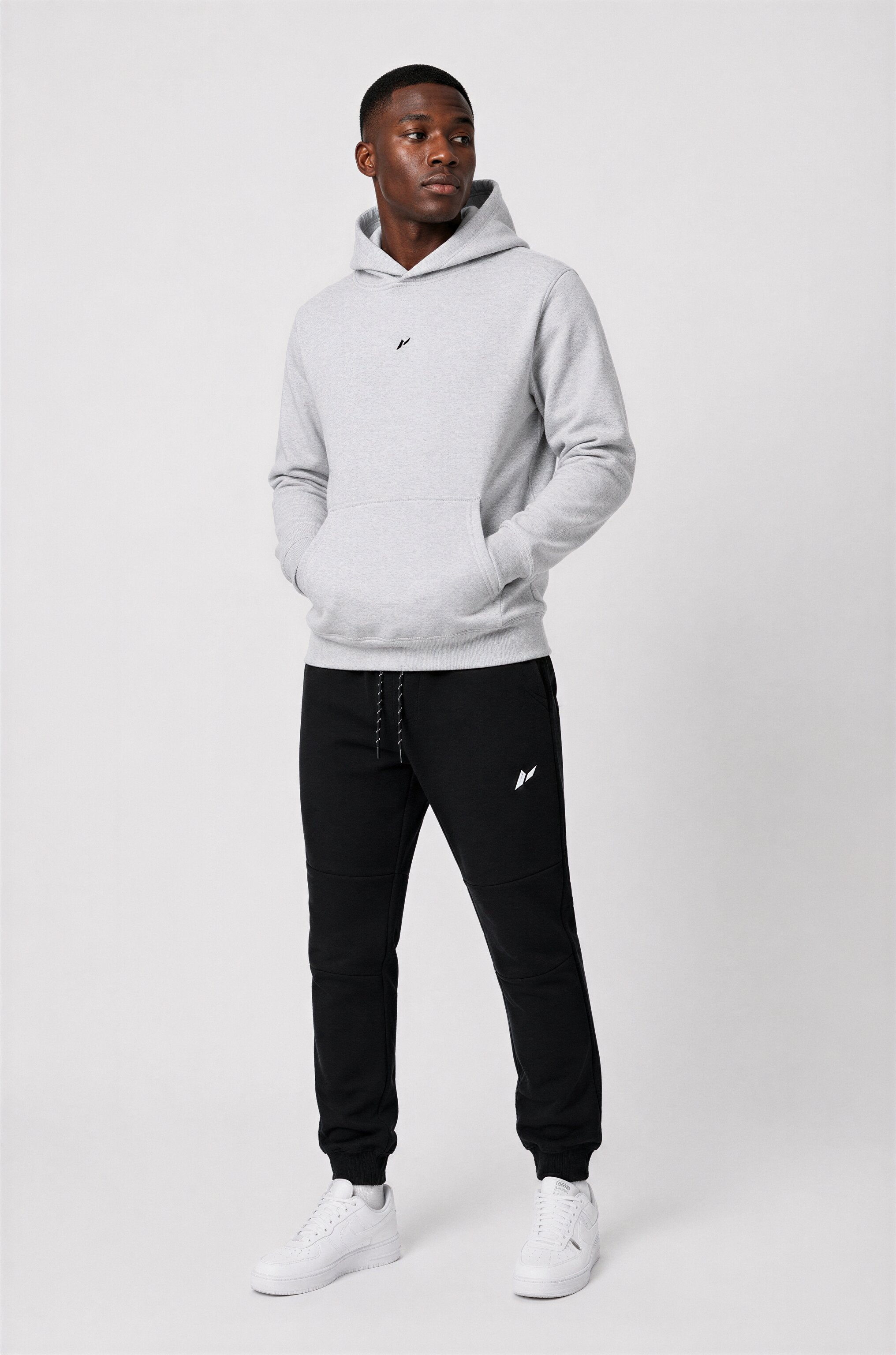 Male athlete wearing Zuva Grey Hoodie with black Zuva track pants and white sneakers — premium mens gymwear Australia