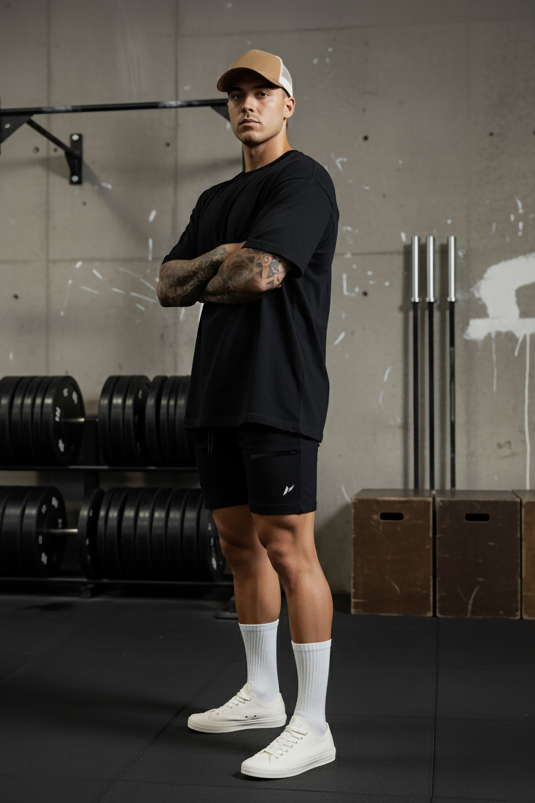 Male athlete wearing oversized t-shirt and Zuva tapered shorts in black standing in the gym